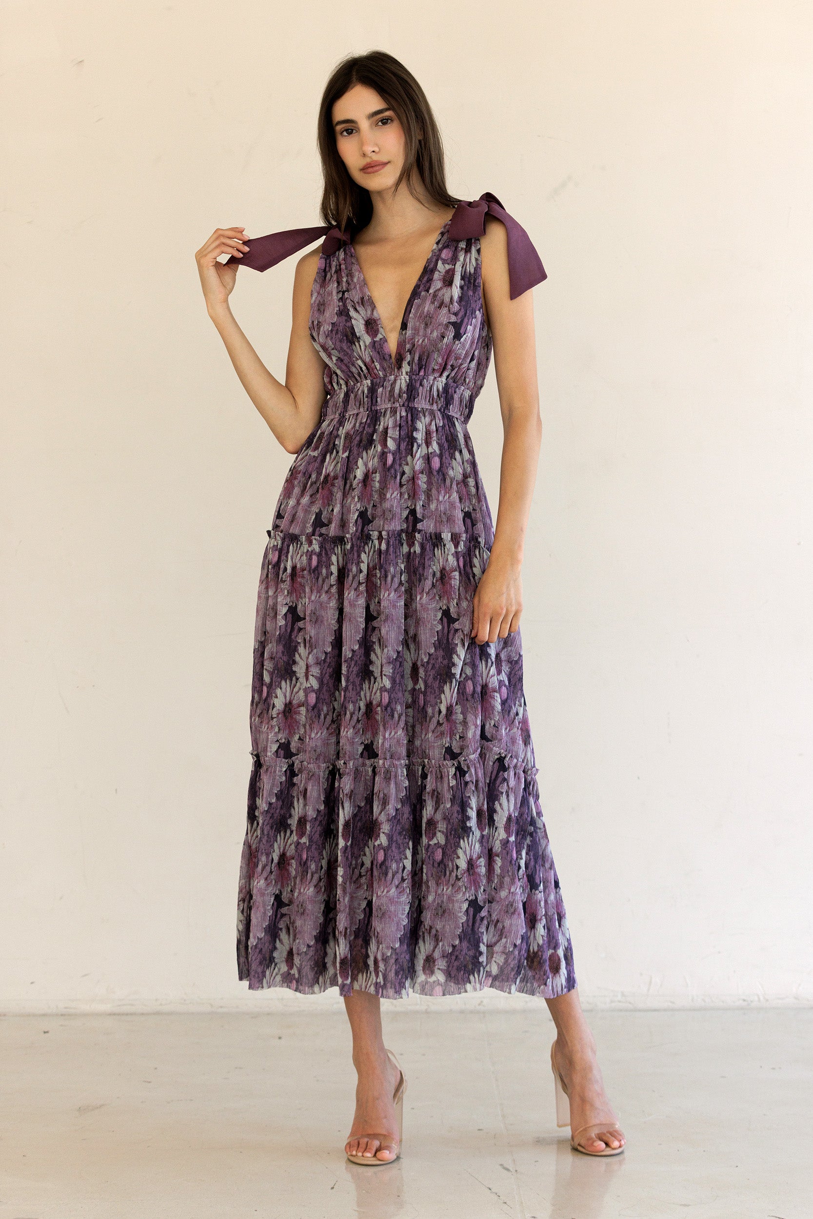 Woman wearing a purple floral dress against a white background