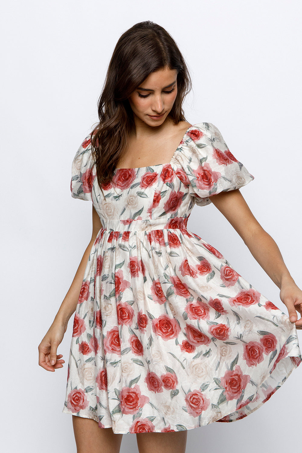 Woman wearing a floral dress with red roses on a white background