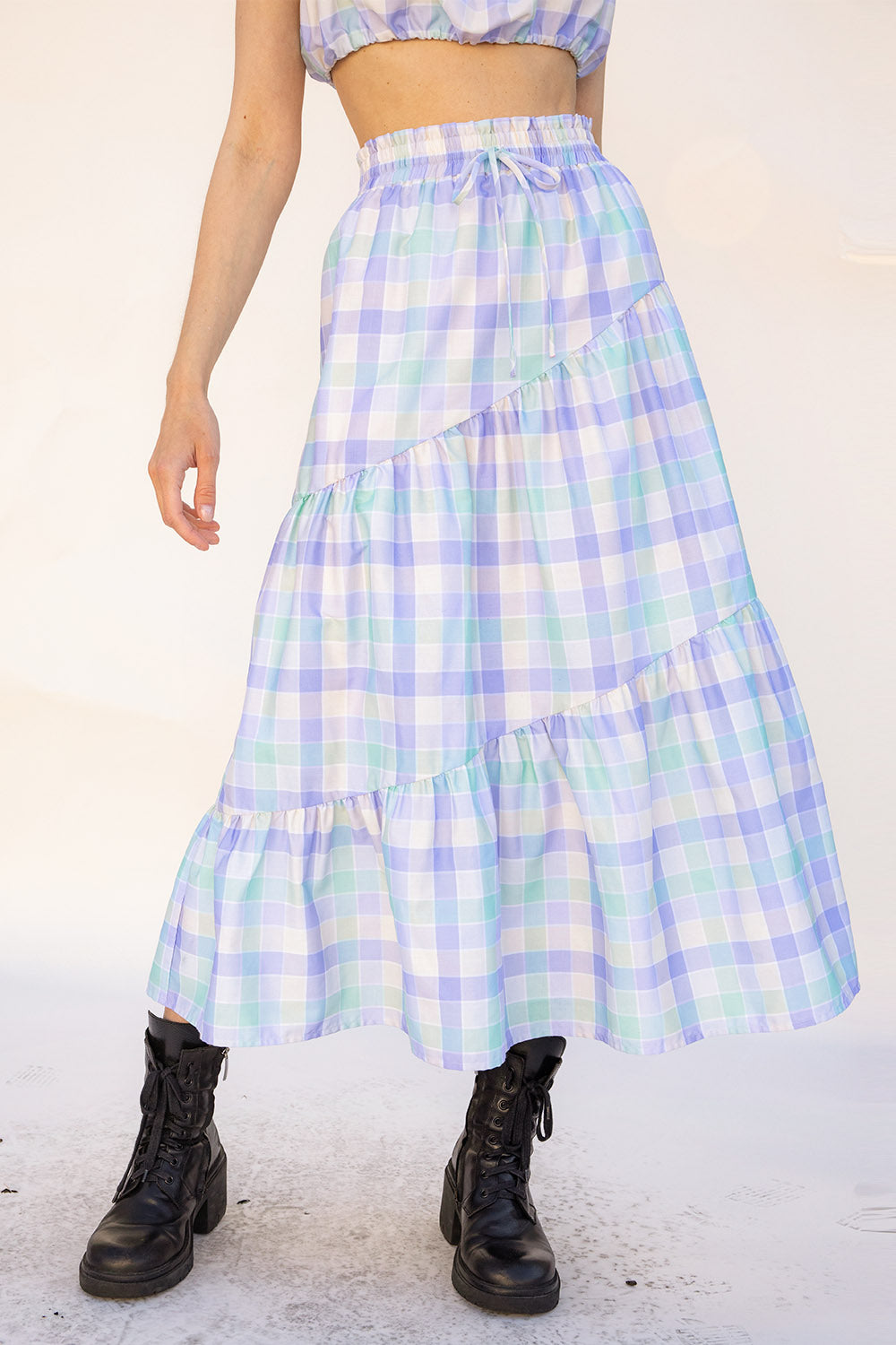 Person wearing a plaid skirt with a white background