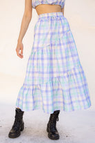 Person wearing a plaid skirt with a white background