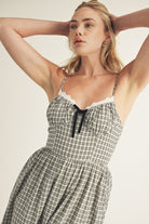 Woman wearing a checkered dress with a white background