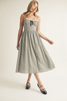 Woman wearing a black and white checkered dress on a plain background