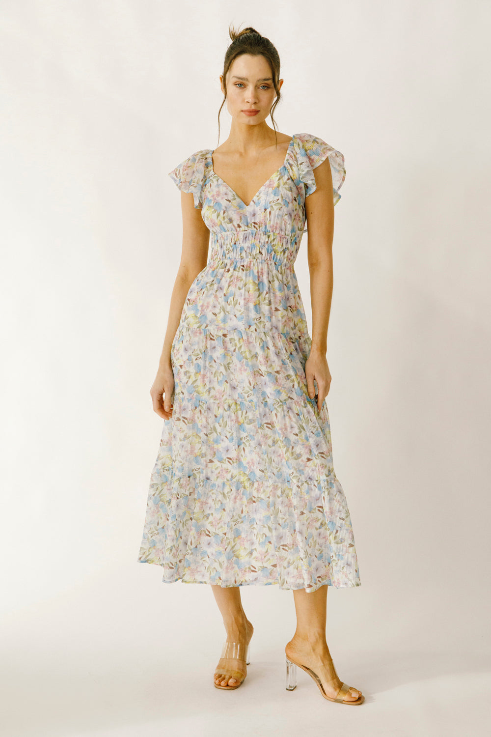 Woman wearing a blue and pink floral dress on a white background