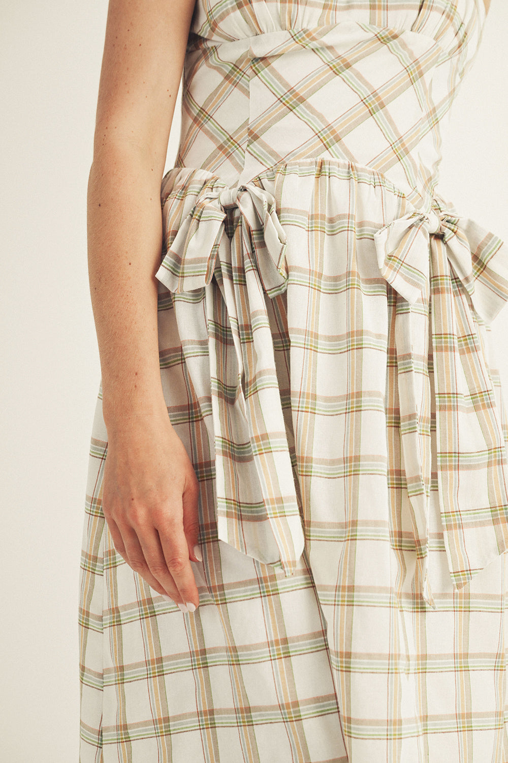 Mint and brown plaid dress with a tie waist on a plain background