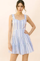 Woman wearing a blue and white striped dress on a beige background