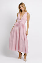 Woman wearing a pink midi dress on a white background