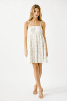Woman wearing a white dress with a subtle pattern on a white background