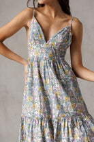 Woman wearing a floral dress against a neutral background