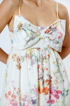 Floral dress with a large bow detail on a white background