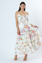 Woman wearing a floral dress with a large bow detail on a white background