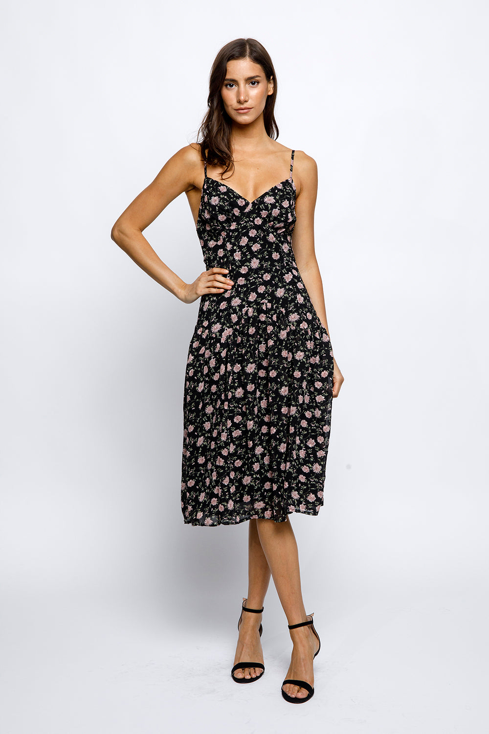 Woman wearing a black floral dress on a white background