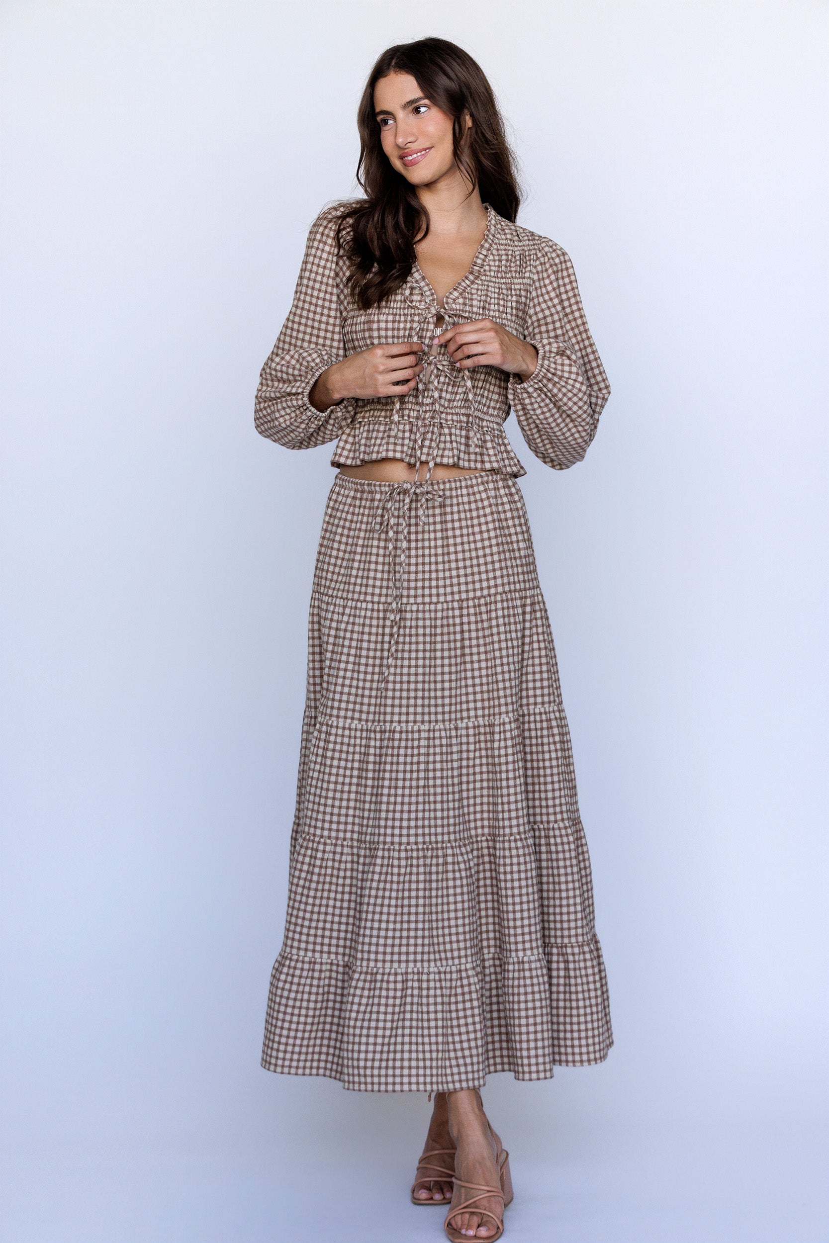 Woman wearing a brown checkered set on a white background