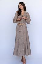 Woman wearing a brown checkered set on a white background