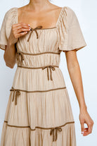 Beige dress with brown accents on a white background