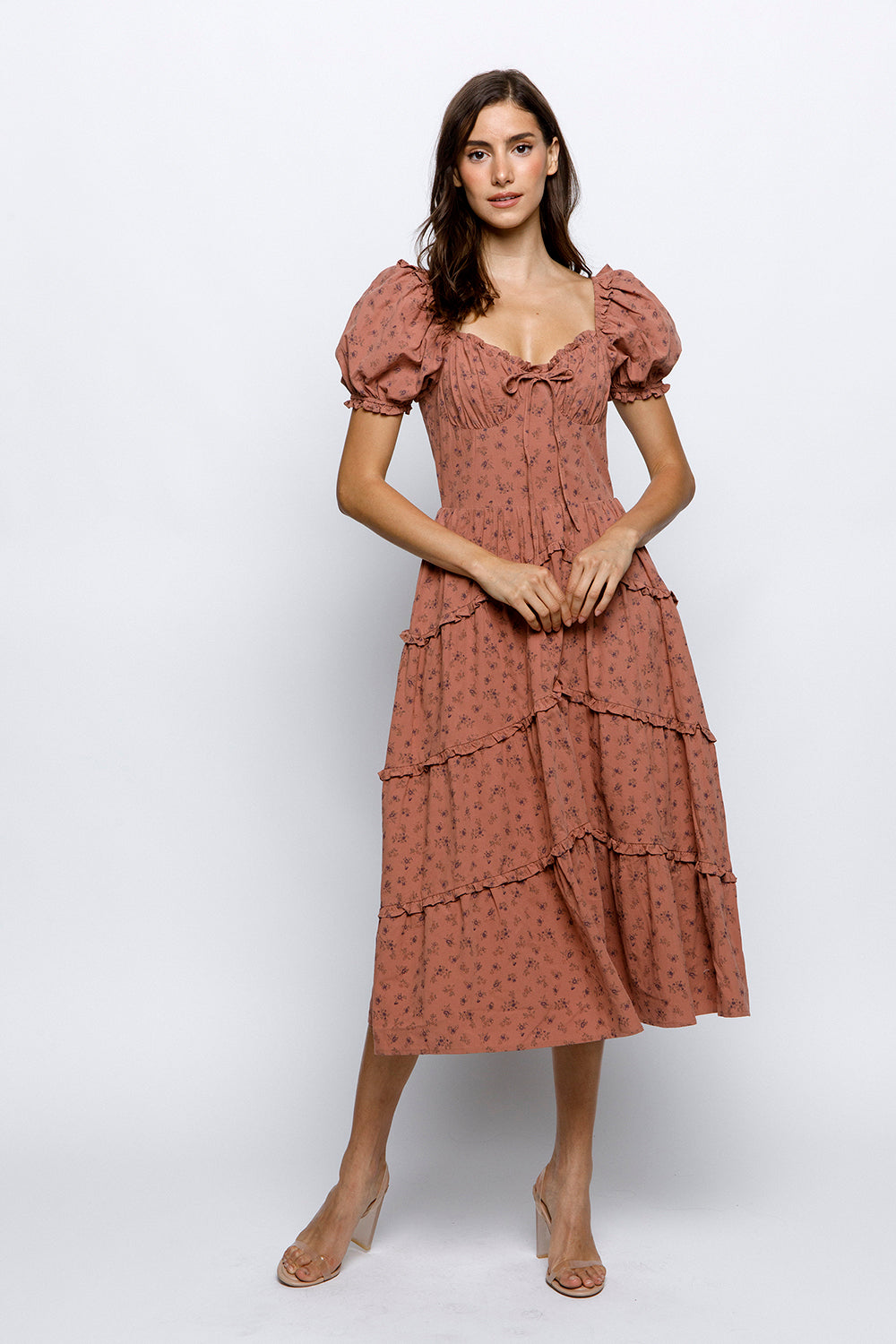 Woman wearing a mauve floral dress on a white background