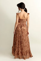 Back view of a woman wearing a brown floral dress on a white background
