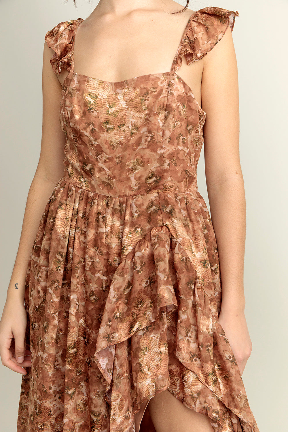 Close-up view of a brown floral dress with a neutral background