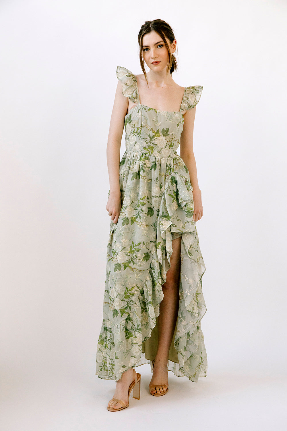 Woman wearing a green floral dress on a white background