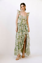 Woman wearing a green floral dress on a white background