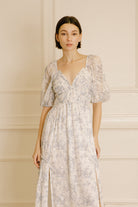 Woman wearing a floral dress against a neutral background
