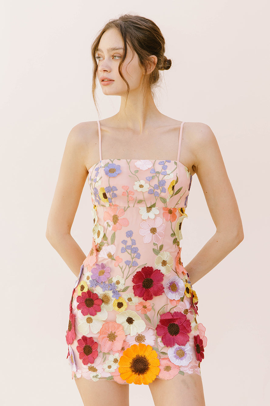 Alternative view of a woman wearing a floral dress on a plain background