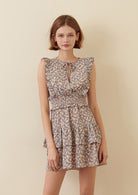 Woman wearing a blue floral dress on a beige background