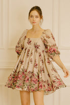 Woman wearing a floral dress against a neutral background