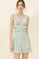 Woman wearing a blue dress with floral pattern on a beige background