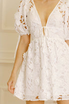 White lace dress against a neutral wall