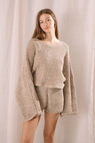 Woman wearing a knitted outfit against a plain background