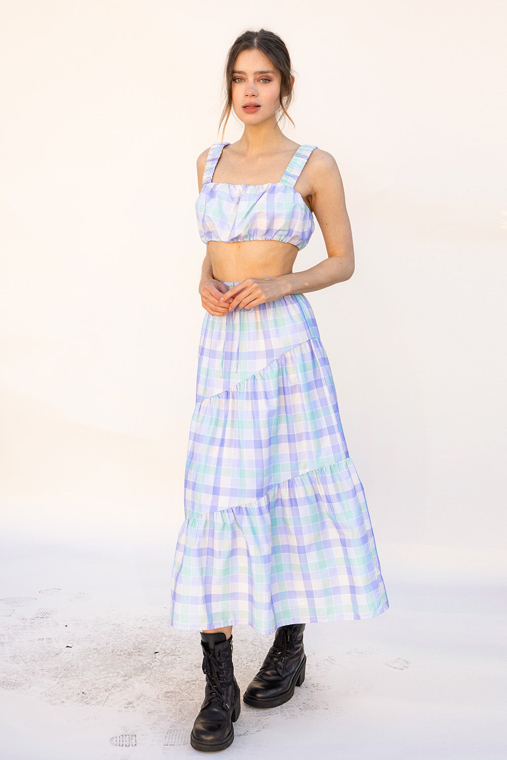Woman wearing a pastel top and skirt on a white background